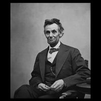 Abraham Lincoln Seated And Holding His Spectacles And A Pencil On Feb 1865 Performance Shirt