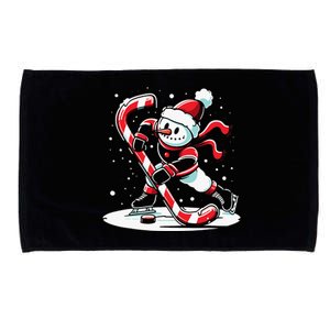 A snowman playing hockey with a candy cane hockey stick Microfiber Hand Towel