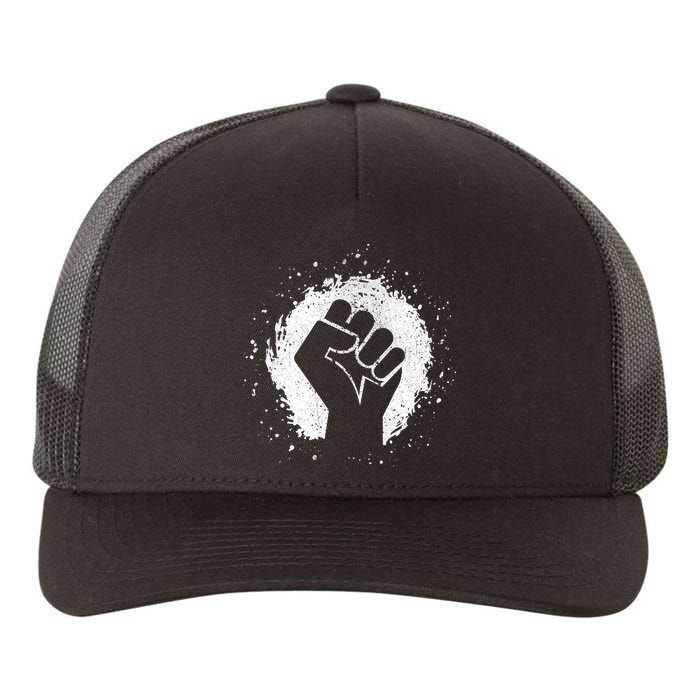 Black History Protest Fist Paint Splatter Yupoong Adult 5-Panel Trucker Hat